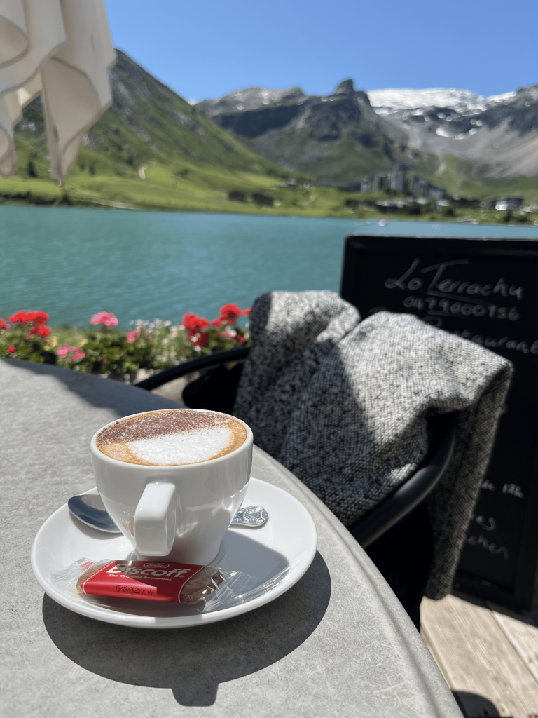 Menikmati secangkir cappuccino di kafe tepi Lac de Tignes.